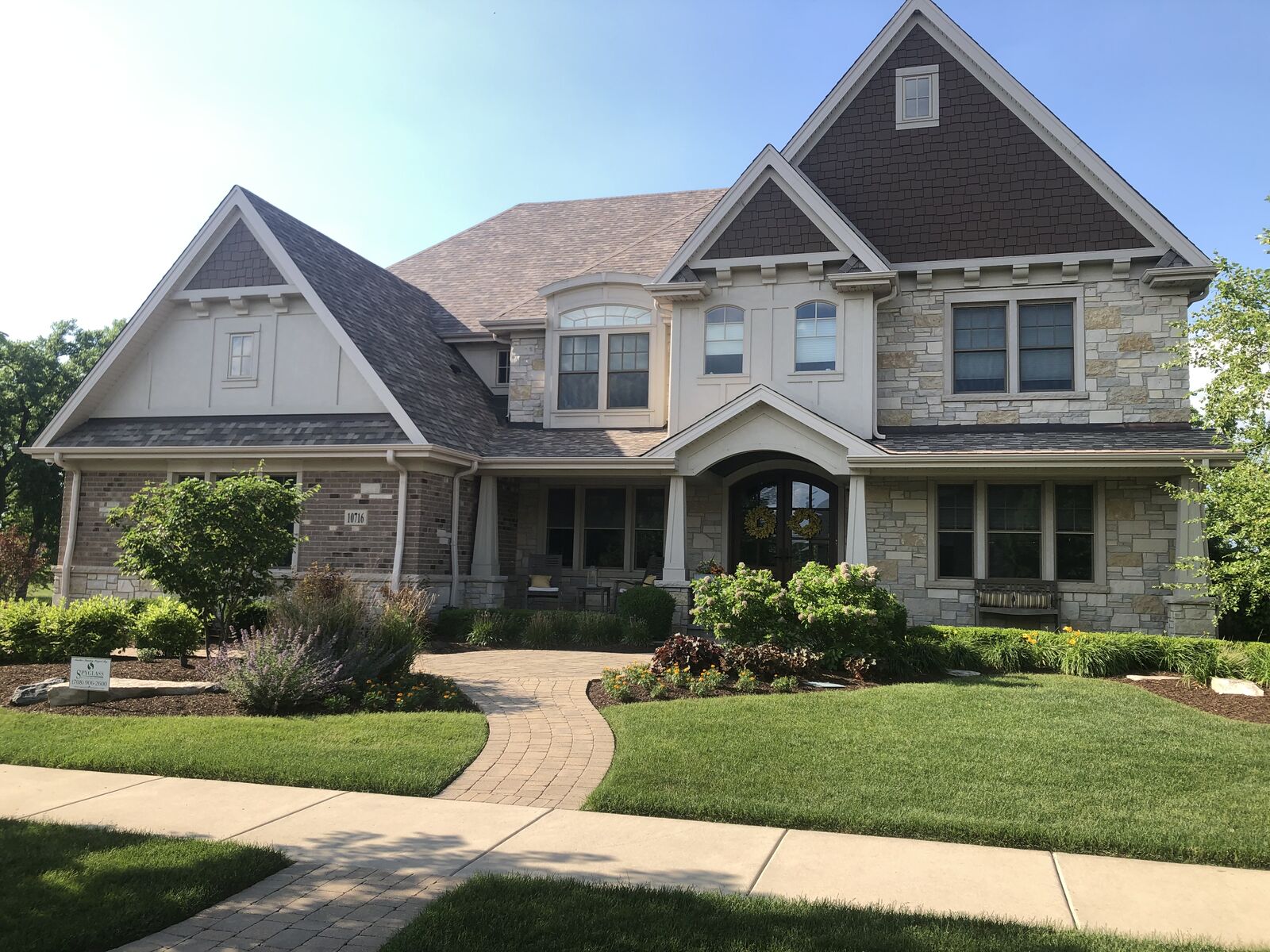 Craftsman shingle style custom home with tapered porch columns, stone and stucco gables built by Spyglass